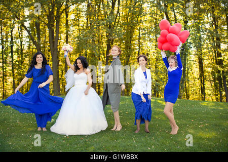 Sposa con i suoi amici a ballare nel prato Foto Stock