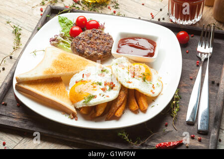 Le carni bovine macinate sul grill, uova fritte sunny side fino a pancetta briciole croccanti , Irlandese , toast di frumento o di segala. Foto Stock