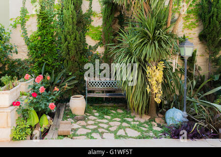 Angolo cucina con un banco e una lanterna nel vecchio giardino Foto Stock