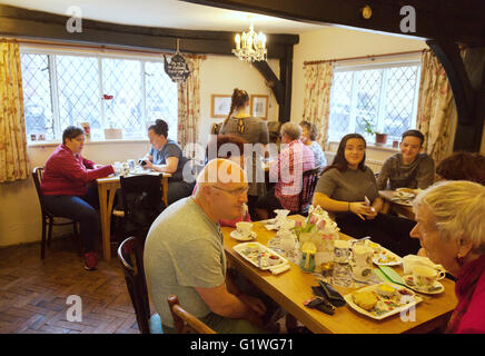 Le persone aventi il tè pomeridiano all'interno del Thomas Oken sale da tè, Warwick, Warwickshire, Regno Unito Foto Stock