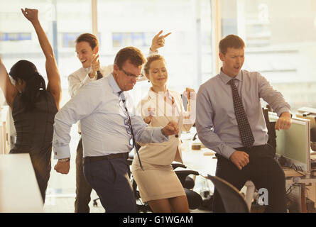Entusiasta la gente di affari che celebra e dancing in office Foto Stock