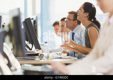Ridendo imprenditrice lavorando al computer in ufficio Foto Stock