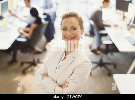 Ritratto di fiducioso imprenditrice con le braccia incrociate in office Foto Stock