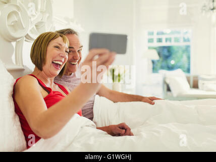 Entusiastico matura un paio tenendo selfie nel letto Foto Stock