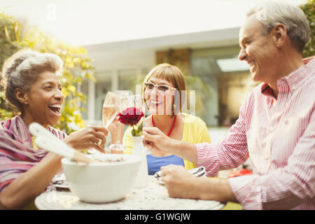 Coppia di amici champagne di tostatura flauti in giardino Foto Stock