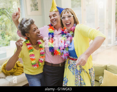 Giocoso adulti maturi ballando con ilo in salotto Foto Stock