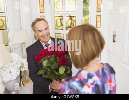 Uomo maturo dando bouquet di rose alla moglie Foto Stock