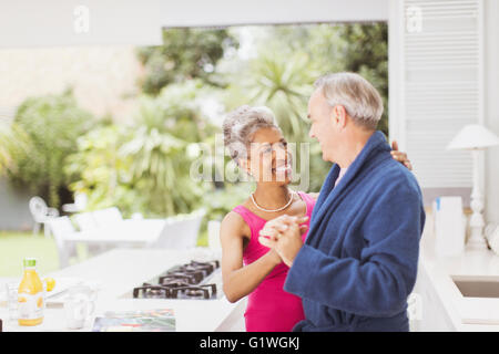 Sorridente Coppia matura dancing in cucina Foto Stock