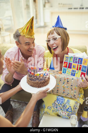 Sorridente donne mature la ricezione di torta di compleanno e regali Foto Stock