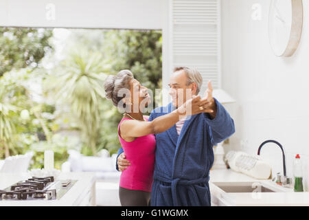Giocoso Coppia matura dancing in cucina Foto Stock