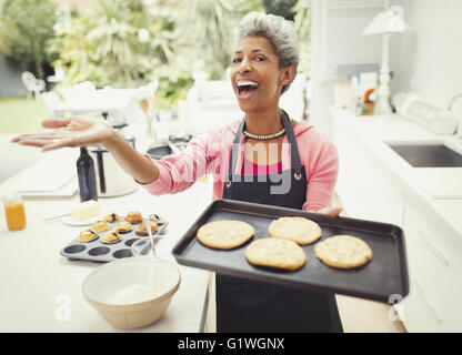 Ritratto entusiastico donna matura i biscotti di cottura e cucina Foto Stock