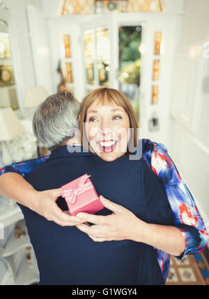 Sorpresa donna matura la ricezione di dono dal marito Foto Stock