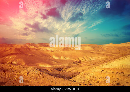 Deserto di montagna con colorati cielo nuvoloso. Deserto della Giudea in Israele al tramonto Foto Stock