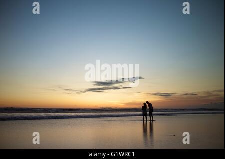 Giovane sulla romantica passeggiata sulla spiaggia di Kuta Beach sull'isola di Bali in Indonesia. Foto Stock