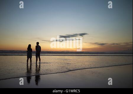 Giovane sulla romantica passeggiata sulla spiaggia di Kuta Beach sull'isola di Bali in Indonesia. Foto Stock