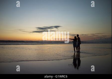 Giovane sulla romantica passeggiata sulla spiaggia di Kuta Beach a Bali, Indonesia. Foto Stock