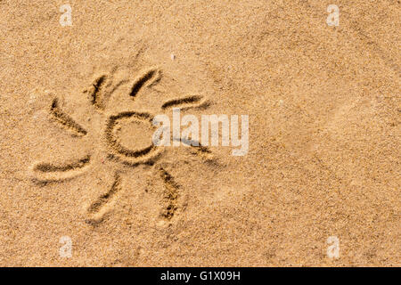 Sun disegnato sulla sabbia del mare Foto Stock