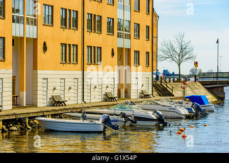 Karlskrona, Svezia - 3 Maggio 2016: Coastal appartamento edificio a Stumholmen in città. Edificio è giallo. Piccole barche da diporto Foto Stock