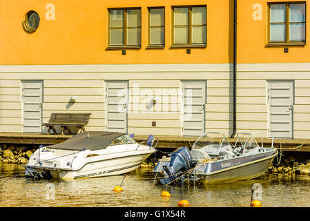 Karlskrona, Svezia - 3 Maggio 2016: Coastal appartamento edificio a Stumholmen in città. Edificio è giallo. Piccole barche da diporto Foto Stock