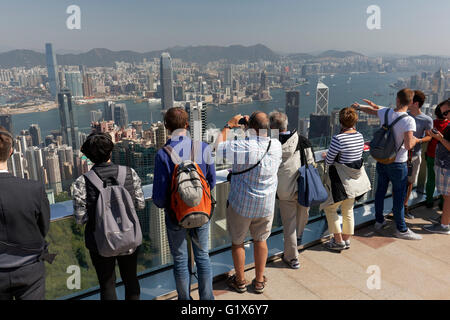 I turisti sul ponte di osservazione di picco, il Victoria Peak, la vista del porto di Victoria e di Kowloon, Isola di Hong Kong, Hong Kong Foto Stock