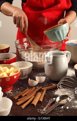 Foto di una femmina di miscelazione degli ingredienti in una grande ciotola di vetro. Potrebbe essere muffin, biscotti, pane, ecc. Foto Stock