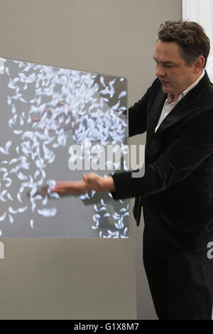 Londra, Regno Unito. 19 maggio 2016. Foto: l'artista inglese Dominic harris dimostra la sua opera interattiva piume. L'arte16 arte fiera si apre a Olympia, Londra ed è aperta al pubblico dal 19 al 22 maggio 2016. arte16 dispone di 100 gallerie provenienti da oltre 30 paesi e sarà vetrina byinternationally opere di celebri artisti tra cui Damien Hirst e polly morgan nonché artisti emergenti di tutto il mondo. Foto Stock