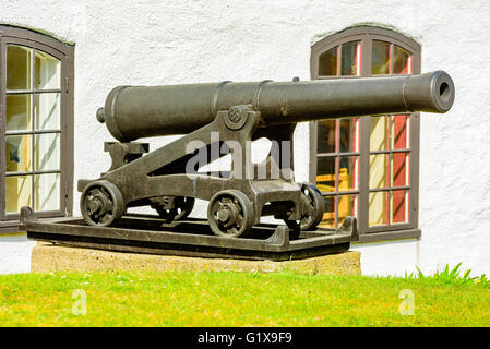 Un vecchio, ferro antico cannone utilizzato originariamente su una vecchia nave a vela. Qui si vede al di fuori di un edificio, ripulito e sul display in p Foto Stock