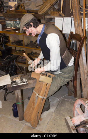 Dent Museo del villaggio e il centro del patrimonio, ammaccature, Yorkshire Dales, Inghilterra. Una dimensione di vita il modello di un uomo che fa un rastrello da fieno. Foto Stock