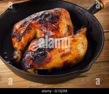 Arrosto di cosce di pollo su un vintage padella in ghisa. Vista superiore Foto Stock