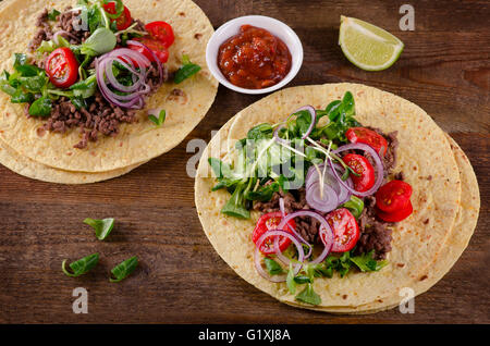 Due tacos messicano sul tavolo di legno. Vista superiore Foto Stock