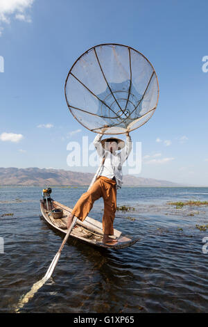 Sul Lago Inle, un pescatore di canottaggio la sua barca con una gamba su un movimento acrobatico (Myanmar) Pêcheur sur le lac inlé (Birmanie) Foto Stock