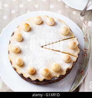 Inglese tradizionale torta di Pasqua con il marzapane di decorazione su una piastra bianca vista superiore Foto Stock