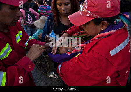 Apr 26, 2016 - La Paz in Bolivia - un piccolo di persone portatrici di handicap i bambini è idratato dai vigili del fuoco dopo una lunga protesta marzo a La Paz in Bolivia. Portatori di handicap protestare in Bolivia. Un piccolo gruppo di persone portatrici di handicap tentare di accedere a una strada a due isolati di distanza dal Palazzo Presidenziale, pesantemente protetti dalla polizia anti-disturba task force. Un sacco di loro cominciano a chiedere denaro per le strade di tornare alle loro città all'interno del paese dopo la mancata partecipazione e avere un colloquio con il Presidente Il Presidente Morales.Il 24 aprile 2016, una di persone portatrici di handicap del movimento nazionale marcia di protesta è venuto per la PA Foto Stock