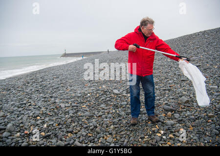 Aberystwyth Wales UK, Sabato 21 Maggio 2016 UK meteo: un ardito volontario viene fuori sotto la pioggia su un umido e miserabili sabato mattina per contribuire a pulire Tanybwlch beach in Aberystwyth. Il popolo, tutti i sostenitori della locale "Aberystwyth Beach Amici" gruppo di Facebook, incontro regolarmente fino a rimuovere le centinaia di pezzi di plastica e di altri rifiuti lavato fino o deliberatamente gettati sulle spiagge intorno a Aberystwyth Photo credit: Keith Morris / Alamy Live News Foto Stock