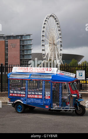 Driver di voler guidare custom-made alimentato da batteria in stile thailandese tuk tuks, elettrico auto-rickshaws in Liverpool, Merseyside, Regno Unito Foto Stock