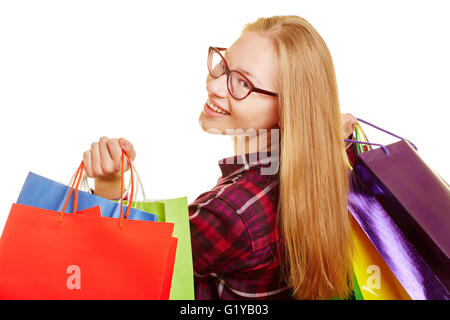 Sorridente donna bionda fatto shopping guarda oltre la sua spalla Foto Stock