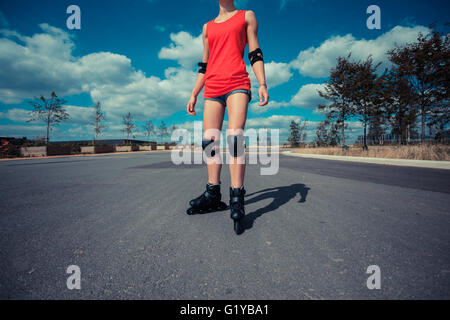 Una giovane donna con i rollerblade in una giornata di sole Foto Stock