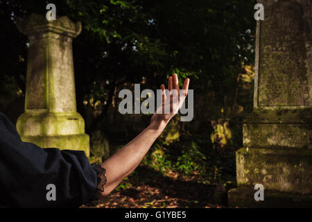 Una giovane donna di mano sollevata da una grave Foto Stock