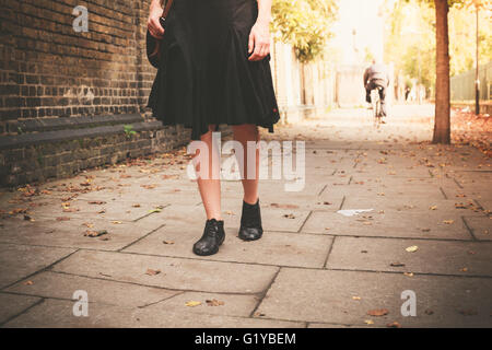 Le gambe di una giovane donna come lei sta camminando in una viuzza in una giornata di sole Foto Stock