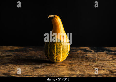 Una zucca su di un tavolo di legno Foto Stock