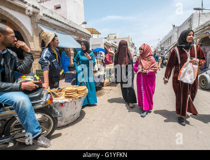 Marocchini andando sulle loro attività quotidiane all'interno della vivace medina (città vecchia) di Essaouira, Marocco Foto Stock