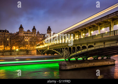Parigi Bir-Hakeim bridge al crepuscolo con le nuvole e la luce delle scie di barche sul Fiume Senna. Sedicesimo arrondissement, 75016, Francia Foto Stock
