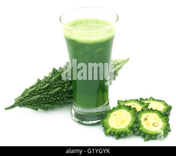Succhi di frutta a base di erbe di momodica verde in un bicchiere con verdure tagliate a fette Foto Stock