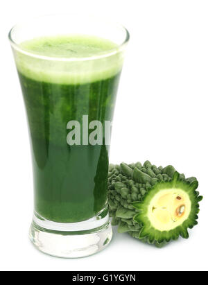 Succhi di frutta a base di erbe di momodica verde in un bicchiere con verdure tagliate a fette Foto Stock