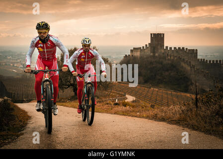 Soave, Italia - 27 Marzo 2016: I ciclisti treno dopo una tempesta sulle colline che circondano il castello di Soave. Foto Stock