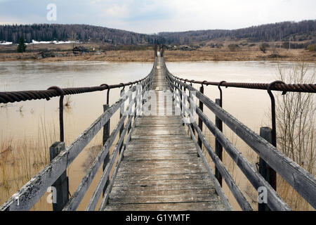 Sospeso il ponte pedonale sul fiume Berd, nel villaggio di Peteni, Novosibirsk Regione Foto Stock