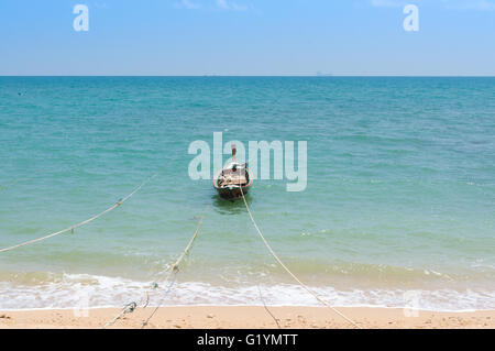 Longtail-Boat ancorato sulla spiaggia di Koh Lanta con fune. Bellissimo oceano turchese e il cielo limpido. Foto Stock