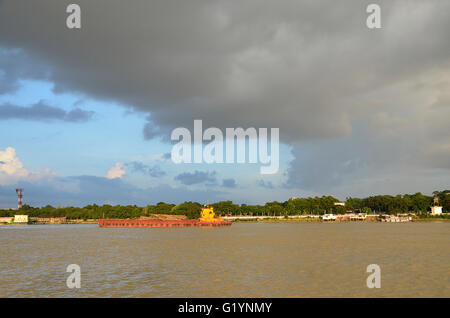 Navi da trasporto sul Fiume Hooghly su un tramonto di monsone, Calcutta, West Bengal, India Foto Stock