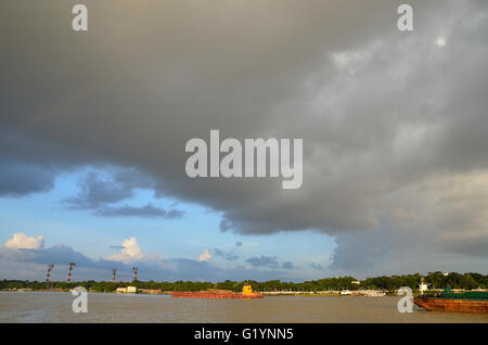 Navi da trasporto sul Fiume Hooghly su un tramonto di monsone, Calcutta, West Bengal, India Foto Stock