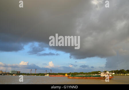 Navi da trasporto sul Fiume Hooghly su un tramonto di monsone, Calcutta, West Bengal, India Foto Stock